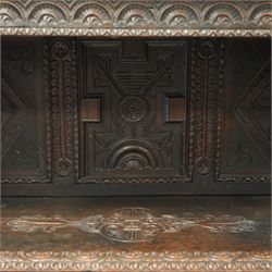 An early 20th-century Jacobean revival style carved oak Court Cupboard, tier-form of 17th-century design, rectangular form with carved back with geometric motifs and arches, projecting top section over twin baluster columns connecting the lower tier above a carved panelled front and panelled cupboard door with profusely carved lozenges and lunettes, above two base drawers, raised on block feet 