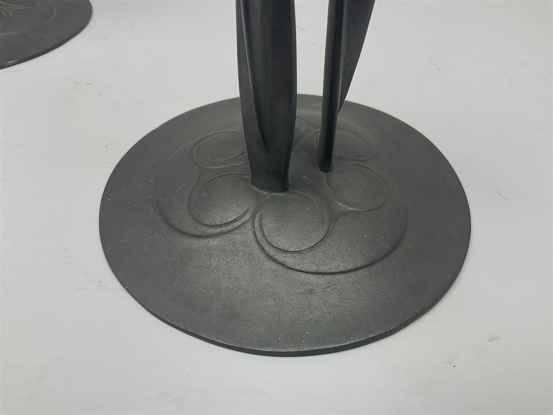 Pair of Solkets English pewter candlesticks, the bud shaped sockets raised upon three angular fin supports and a slightly domed circular base with cast stylised foliate decoration, H23cm