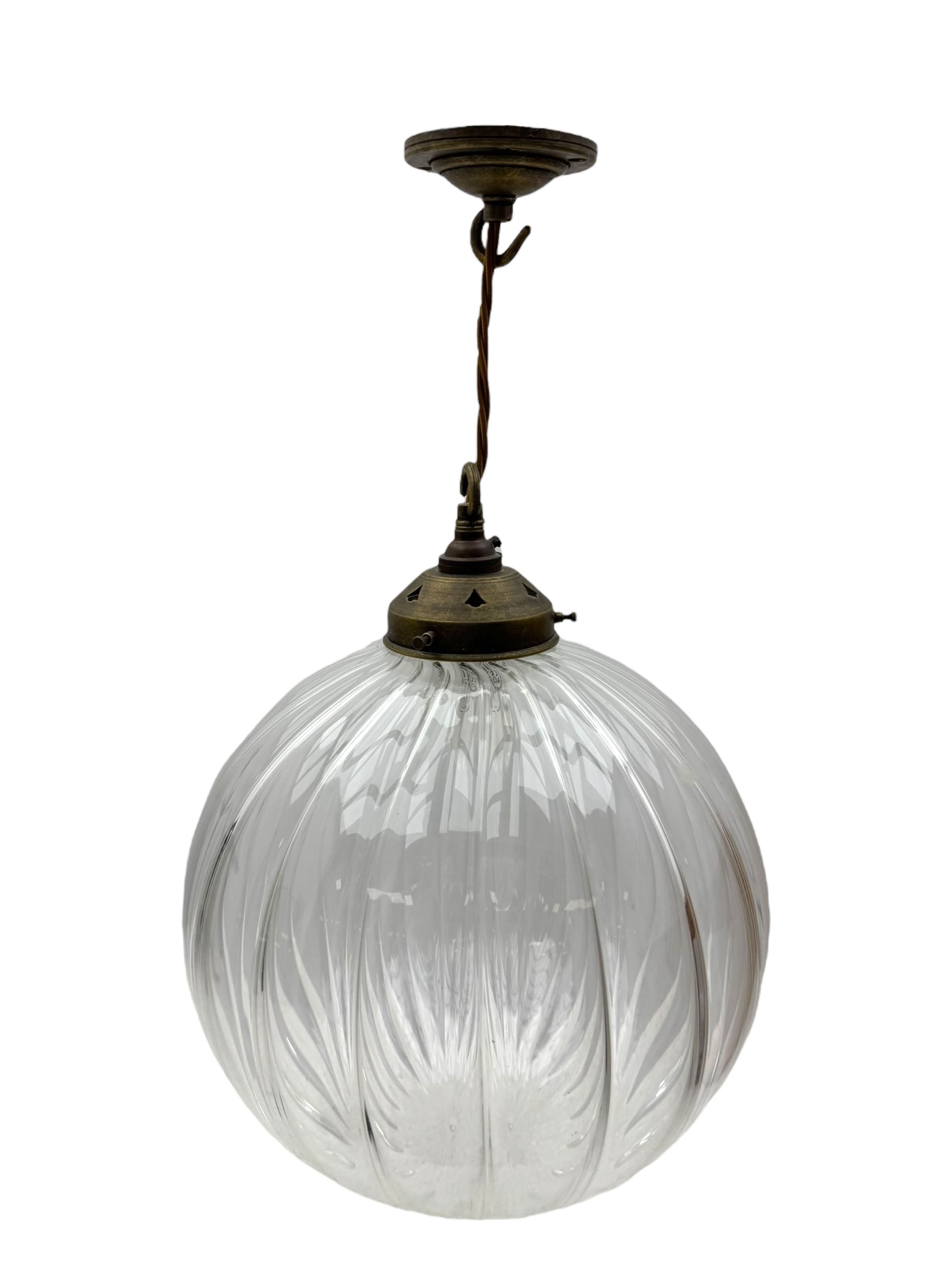 Set of two small and two large pendant lights, each with clear glass spherical shade with moulded swirl pattern, suspended from twisted cords, brass ceiling rose