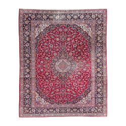 Large Persian Kashan crimson ground carpet, central floral medallion surrounded by swirling leafy branches and palmettes, enclose by floral pattern spandrels, the indigo border with overall scrolling design decorated with palmettes, within guard stripes 