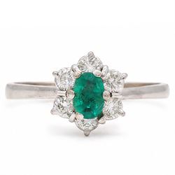 White gold emerald and diamond cluster ring, single oval cut emerald of approx 0.25 carat,...