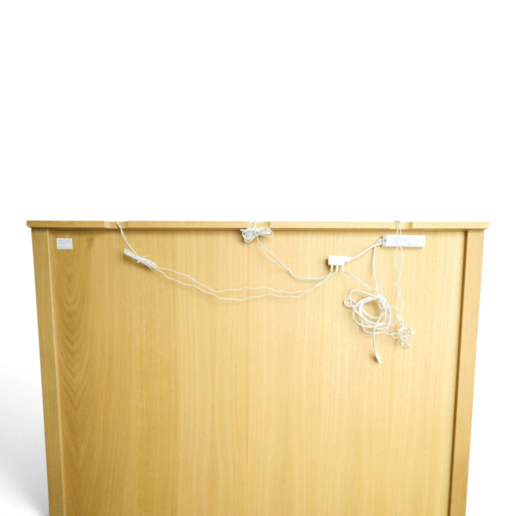 Ercol - 'Artisan' light oak dresser, upper section with cantered corners, with central open area fitted with adjustable glass shelves, flanked by twin glazed cabinets with further adjustable glass shelving, the lower section with three shorts drawers with recessed handles, above three cupboard doors with recessed handles enclosing adjustable wooden shelves, raised on short tapering supports 