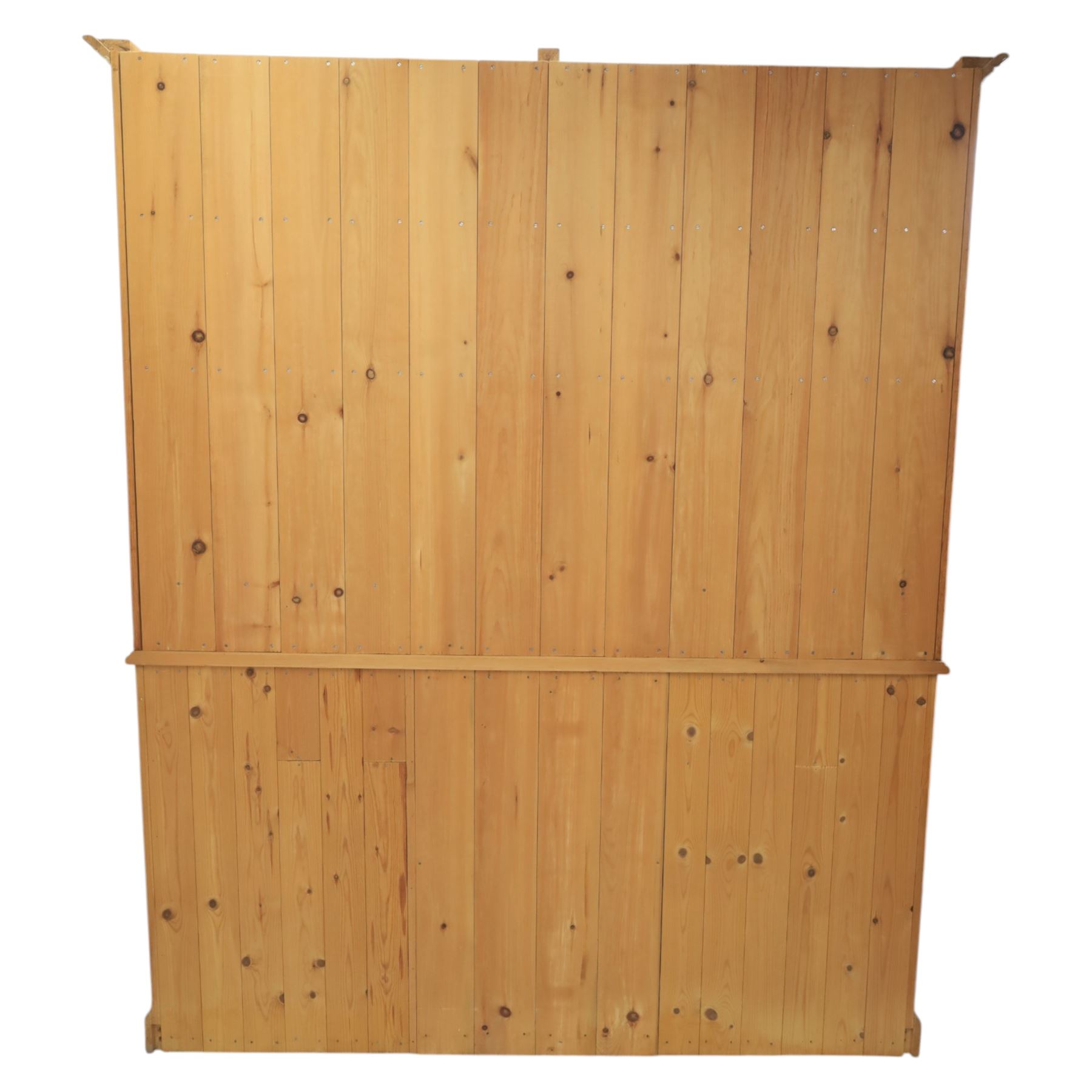 20th century country style waxed pine housekeeper’s cupboard, upper section with moulded cornice, shaped aprons and open shelving around central drawer arrangement, the lower section fitted with three drawers and two cupboards with panelled doors, raised on a plinth base