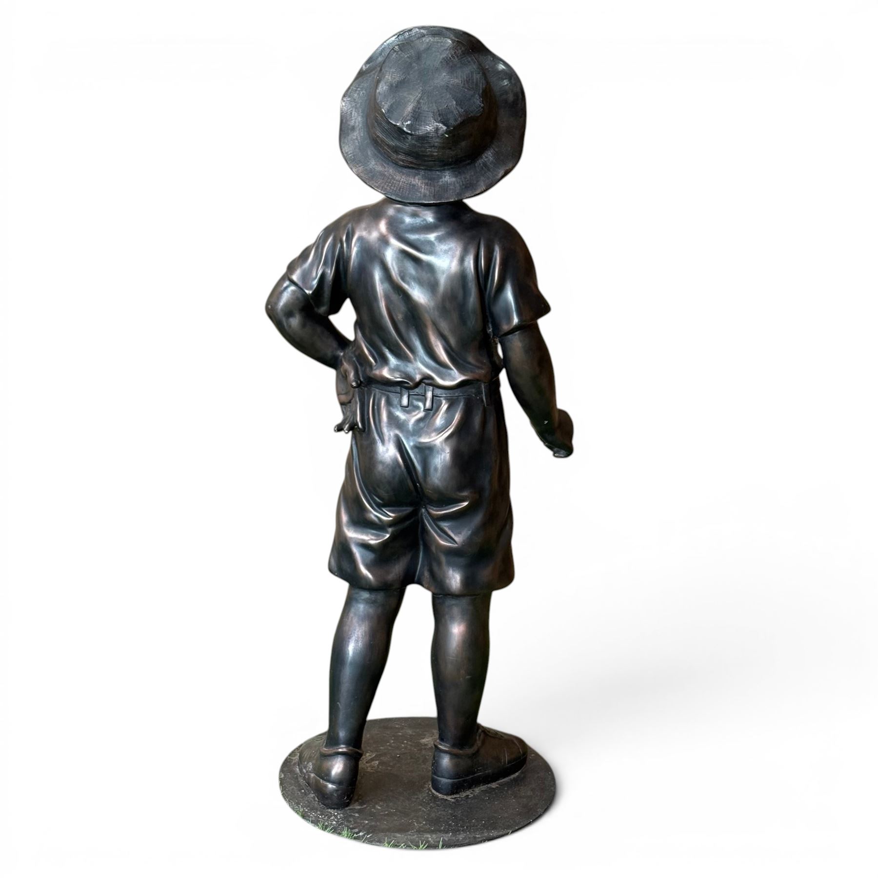 Bronzed composite figure of a boy wearing a hat, on circular plinth
