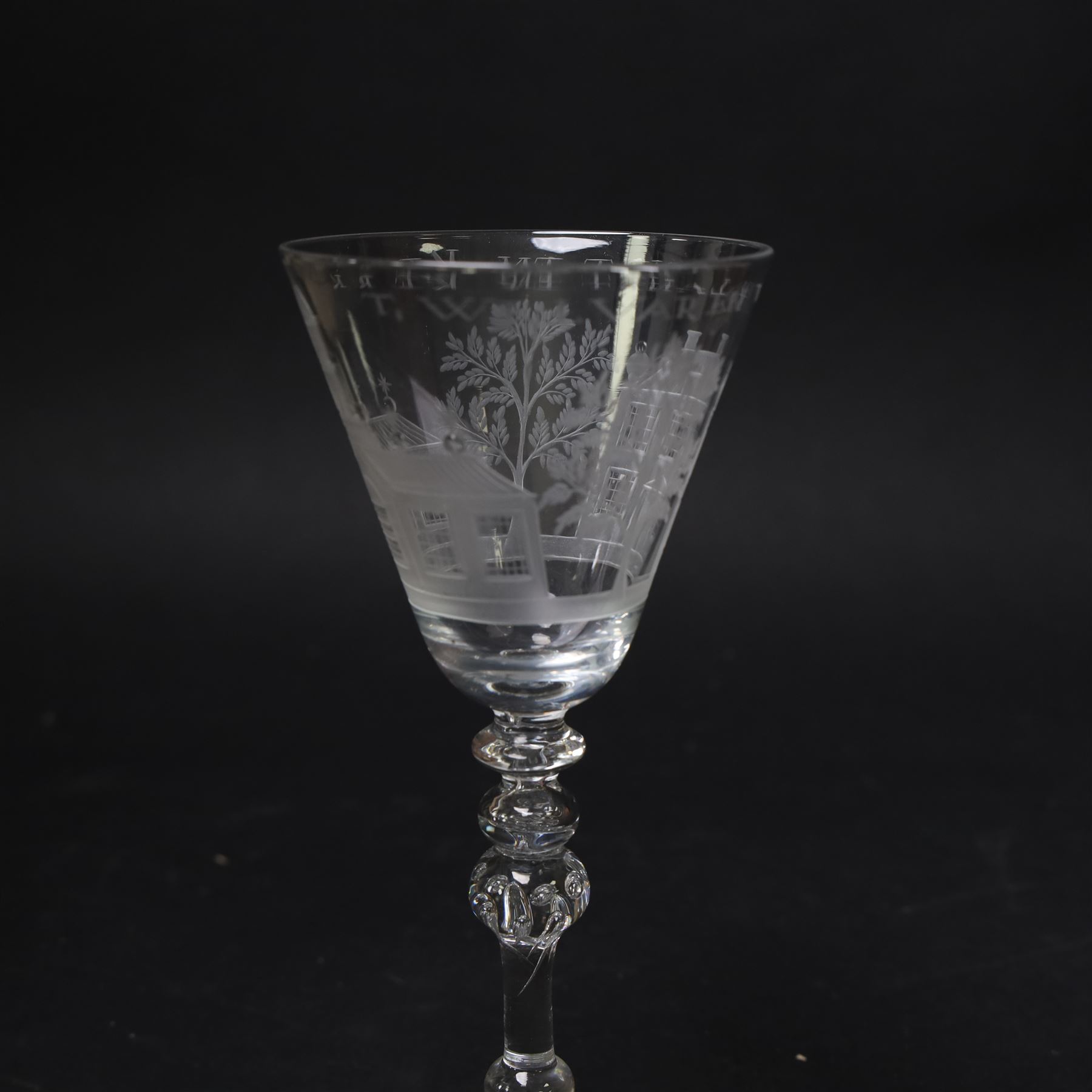 Dutch engraved Newcastle light baluster glass, circa 1760, the funnel bowl engraved with a two storey country house and church flanked by trees, beneath the inscription ‘T WELVAREN VAN LANDT ENKERK’ (The prosperity of the Country and Church), upon a multi knopped stem with beaded knop and basal knop, over conical foot, H18cm



