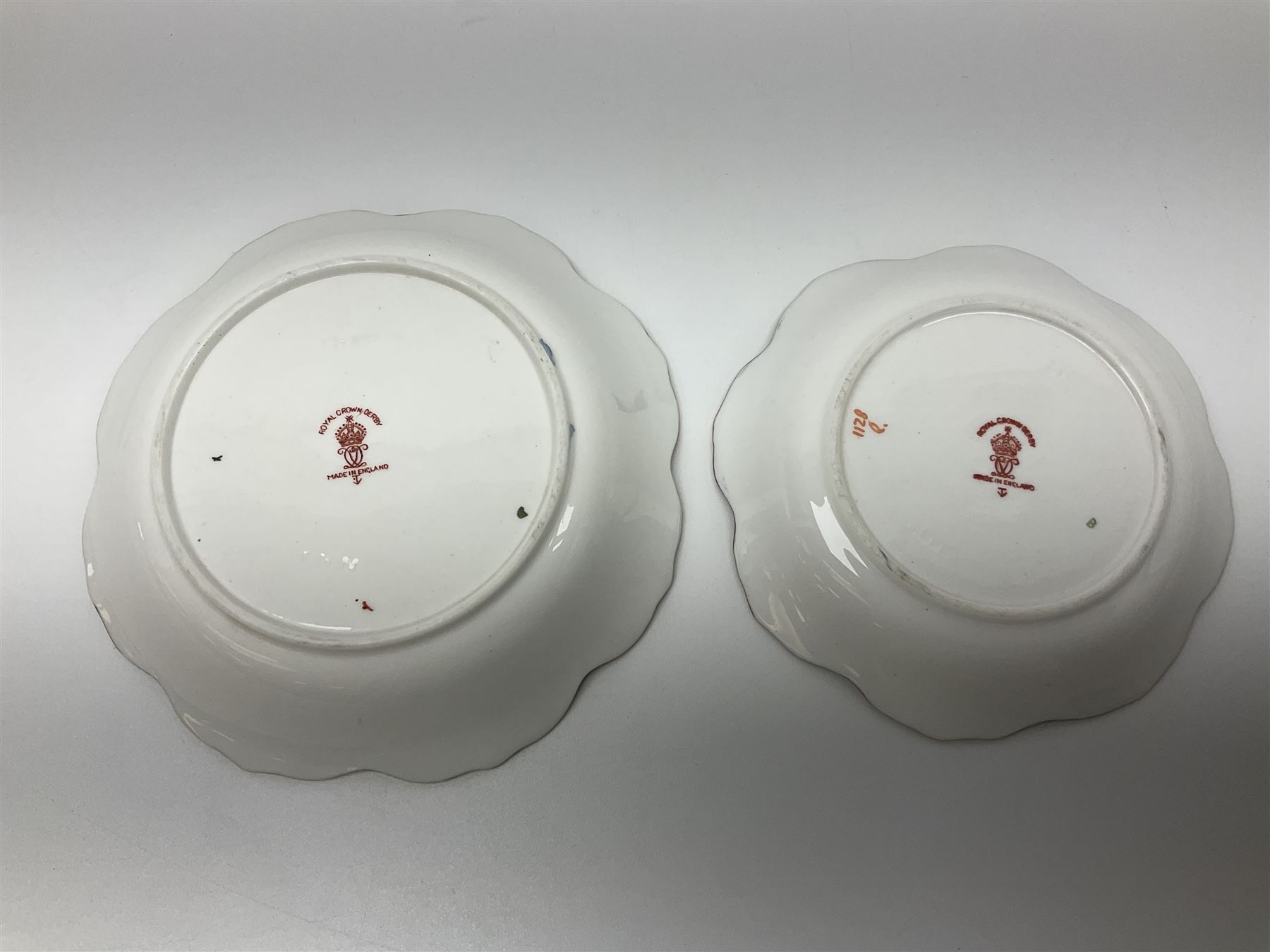 Two Royal Crown Derby Goldfinch Nesting paperweights with silver stoppers, together with two Royal Crown Derby imari pin dishes, largest dish D13cm