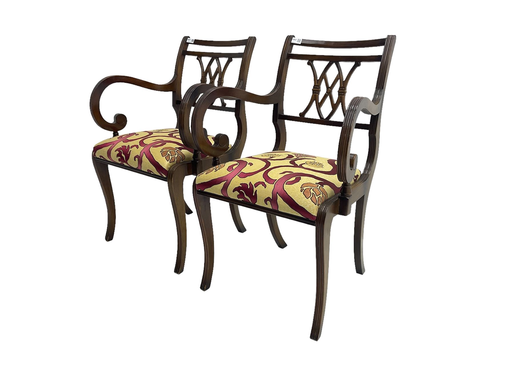 Regency design mahogany twin pedestal dining table, rectangular top with reeded edge, acanthus carved turned column terminating in reeded tripod base with hairy paw feet and castors (W172cm D92cm H75cm) and set eight (6+2) Regency design mahogany dining chairs, pierced back with scroll design, seat upholstered in patterned laurel green fabric, raised on reeded sabre supports (W48cm H88cm)