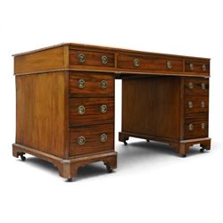 Late Victorian mahogany desk with red leather top, rectangular top with inset toold red leather writing surface, central long frieze drawer flanked by two short drawers, above pedestal with three graduating drawers with ring pull handles, on moulded plinth bases raised on castors