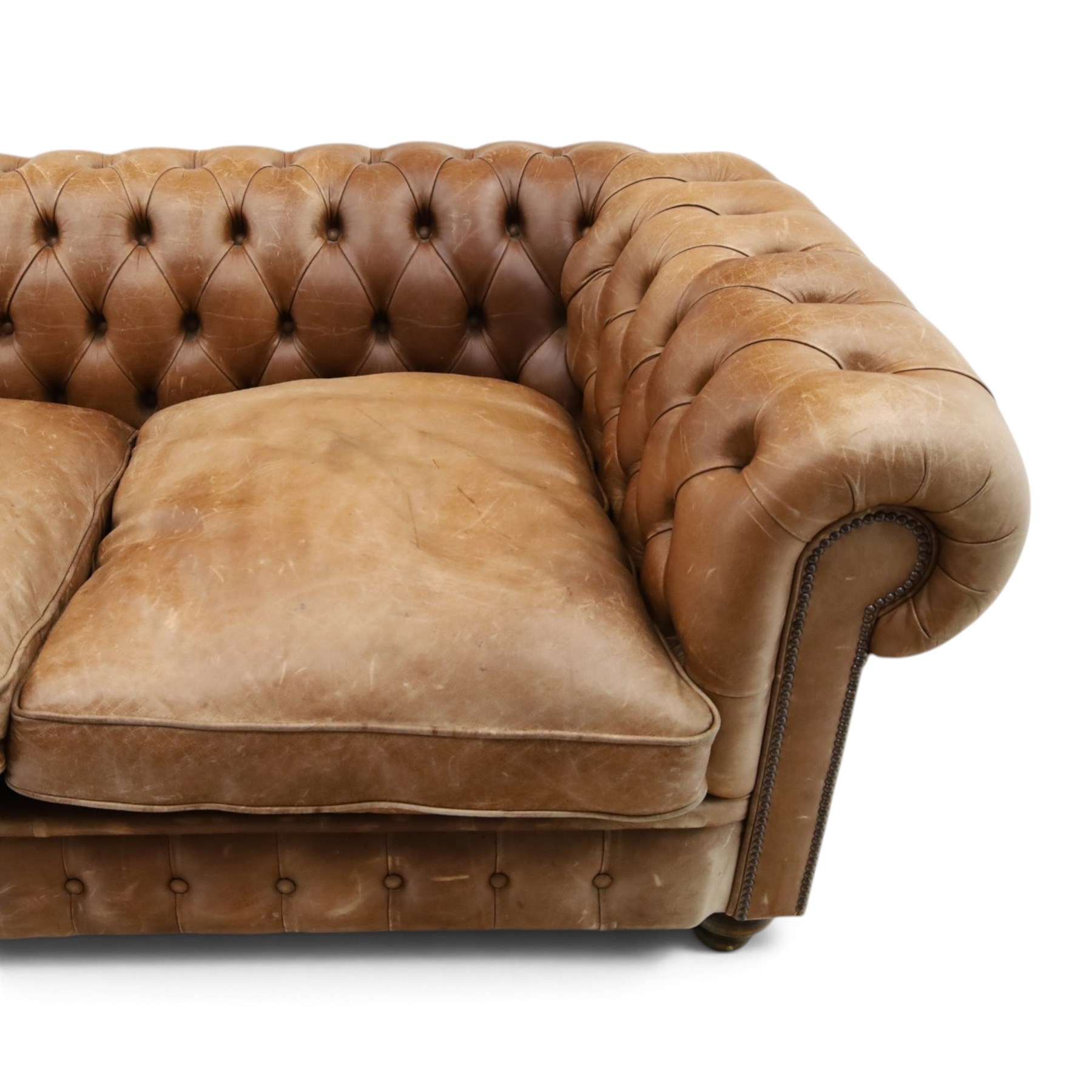 Fleming & Howland Ltd - large traditional shape four seater chesterfield club sofa, the rolled ack and arms with studwork, upholstered in buttoned tan leather with loose seat cushions, raised on large turned feet