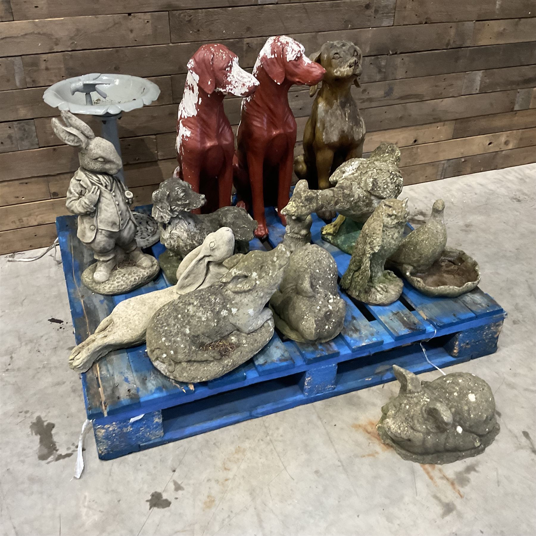 Various cast stone and composite garden ornaments, to include Peter Rabbit, goose, pigs, dogs, dog with wheelbarrow, painted metal bird bath and other, on two pallets