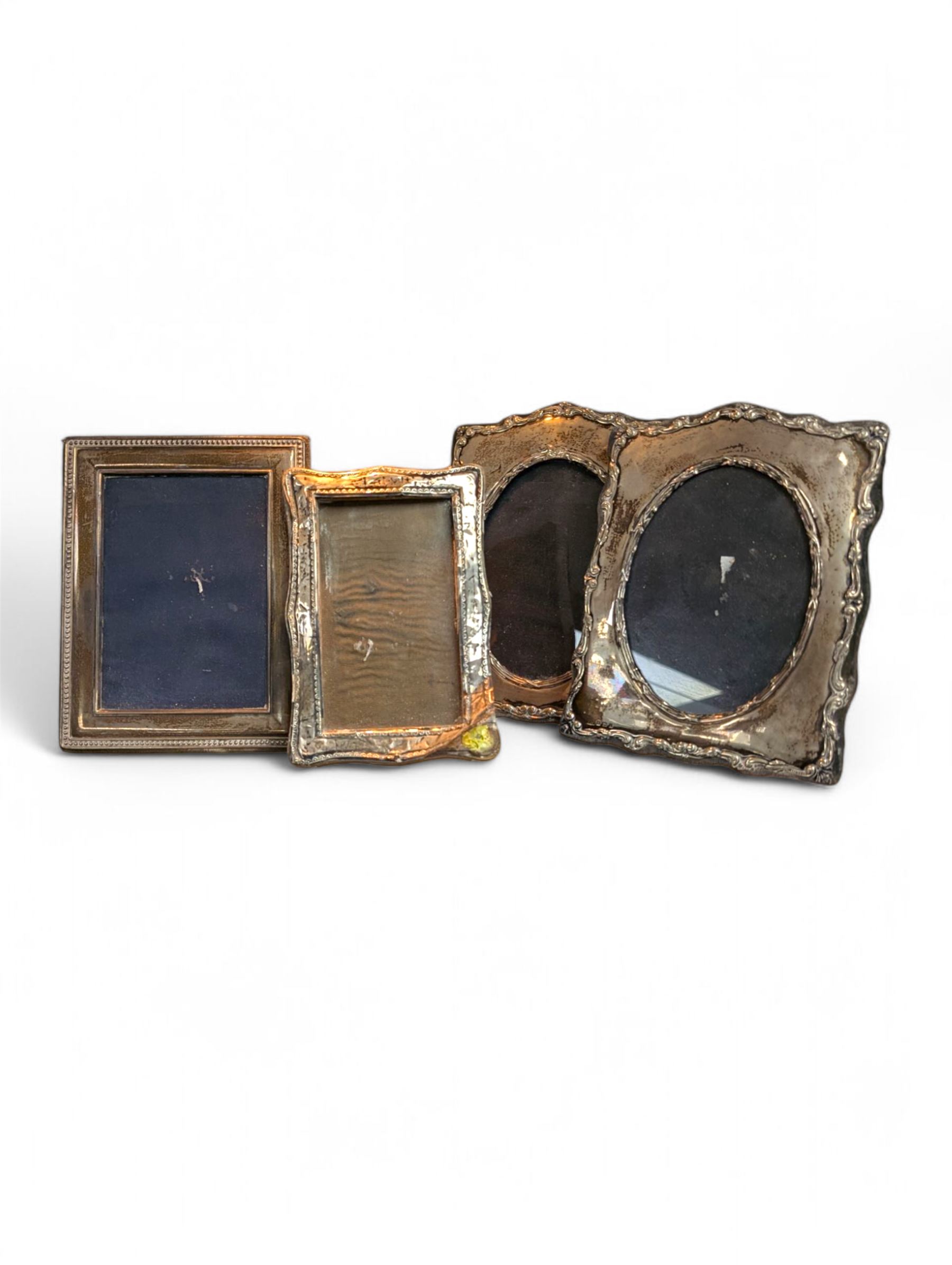 Four silver mounted photograph frames, including Edwardian pair with C scroll and reed and ribbon borders, hallmarked Henry Matthews, Birmingham 1908, tallest H18cm