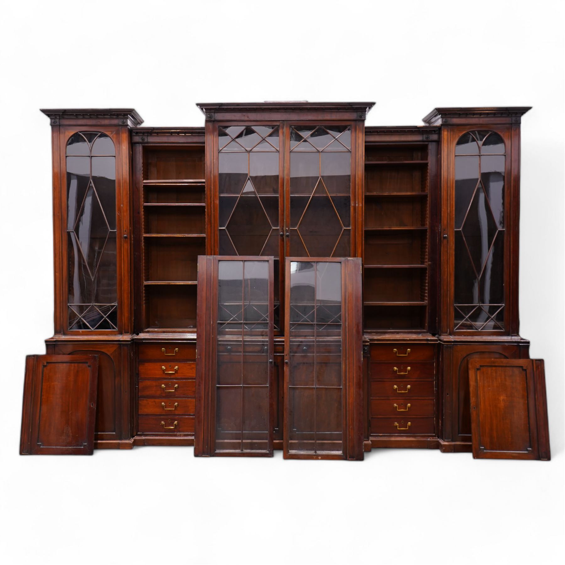 Large Georgian mahogany library bookcase, projecting moulded cornice with row of globular mounts, adjustable shelving enclosed by six astragal glazed doors, fitted with two slides and six panelled cupboard doors, two banks of five drawers, on moulded plinth base; together with two pairs of associated astragal glazed doors in mahogany, from the same property (W55.5cm x H168cm & W48cm x 168cm)