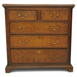 Georgian oak chest of drawers, fitted with two short over three long drawers, with brass swing handles and escutcheons, flanked by quarter turned pilasters, raised on shaped bracket feet