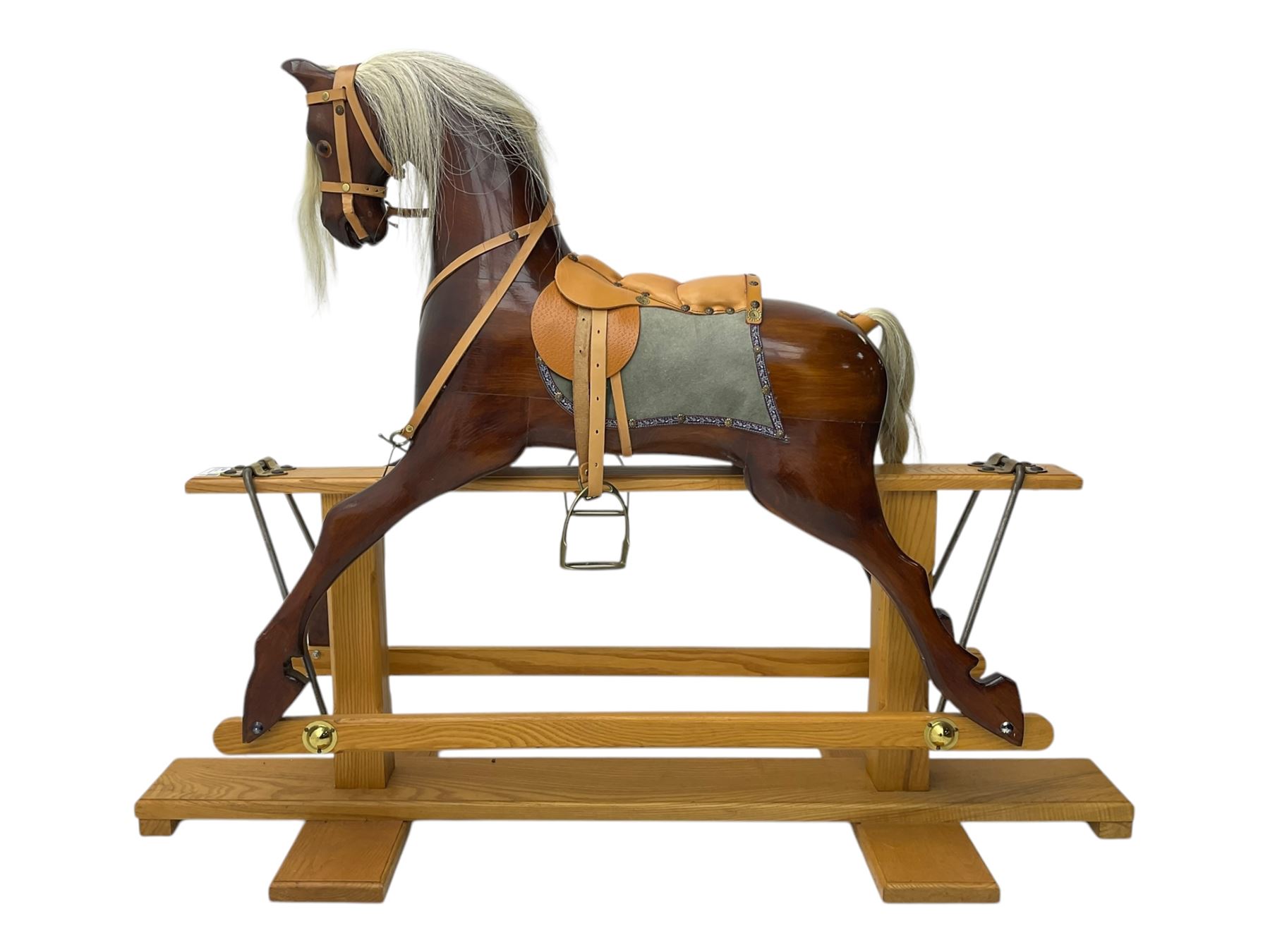Contemporary carved wooden rocking horse, with leather saddle and bridle, horsehair mane and tail, raised on a pine stand with swing iron supports