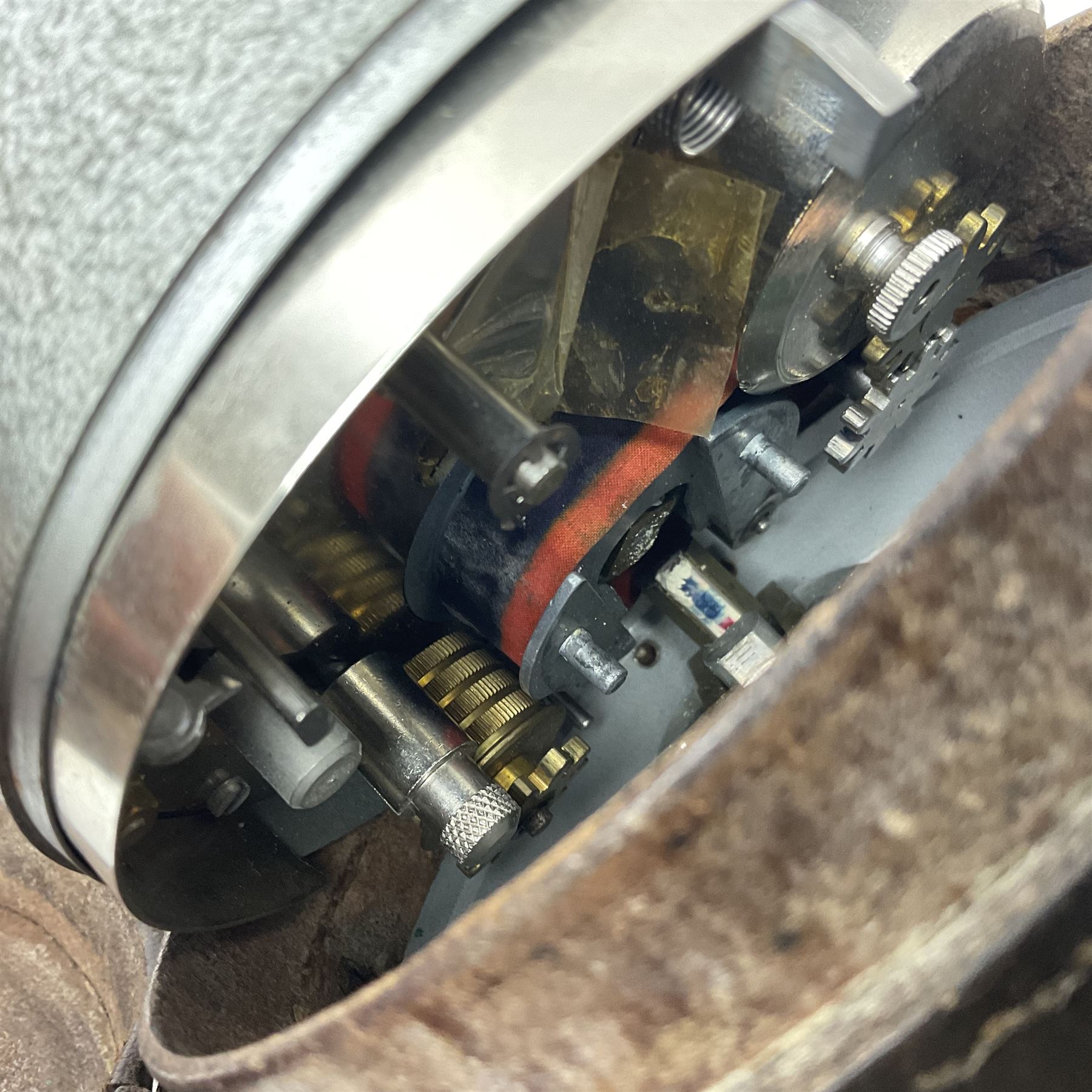 Metal cased drum shaped travelling clock with grey hammered finish, French clockwork movement and stitched leather outer case with shoulder strap; bears manuscript label 'Royal Armament Research and Development Establishment - serial no.09433' D13cm overall