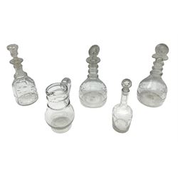 19th century clear glass jug with double ring neck and swan neck handle, together with four 19th century clear glass decanters to include etched examples with triple ring necks, cut examples etc