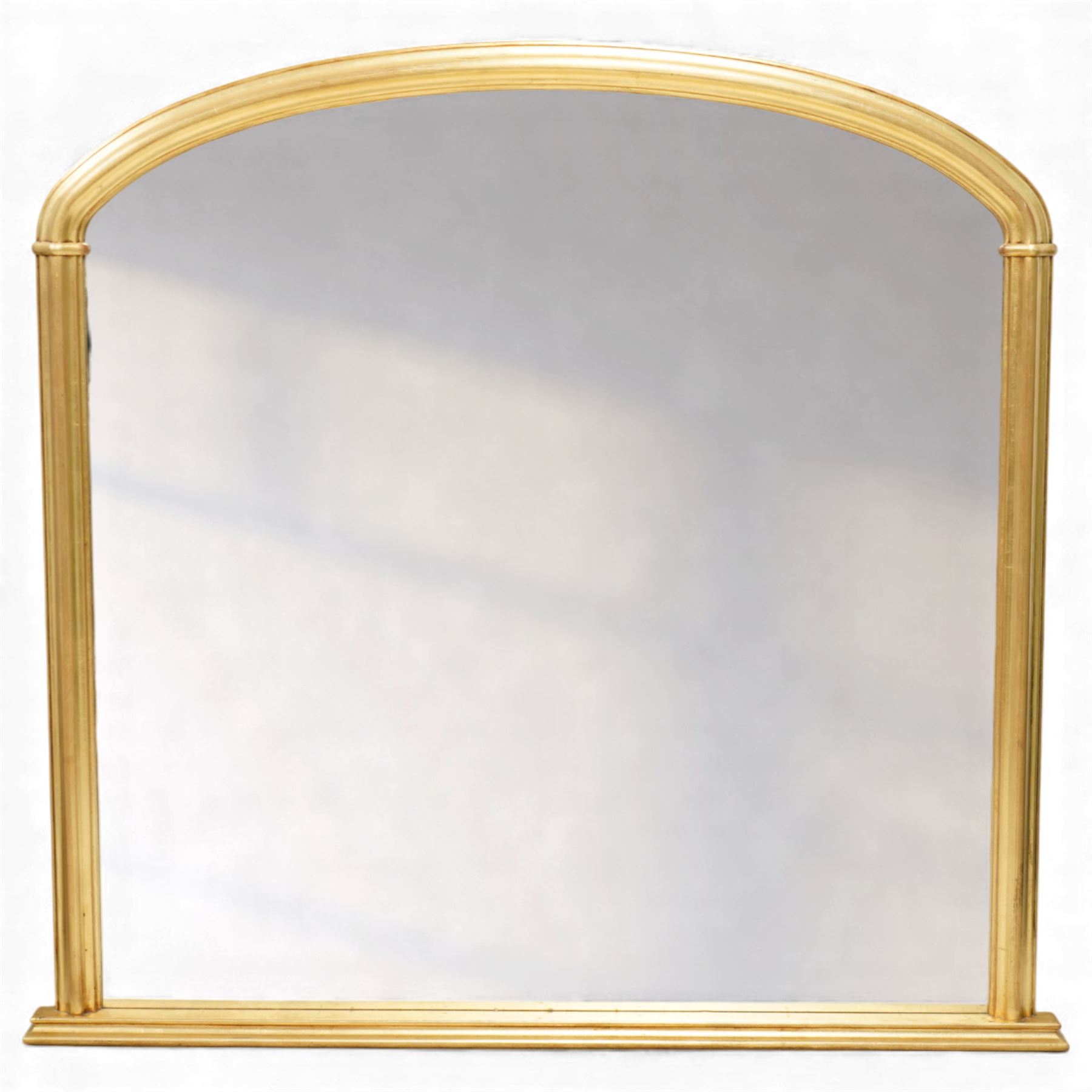 Contemporary large giltwood overmantel mirror, arched rectangular form with reeded moulded frame and stepped lower rail