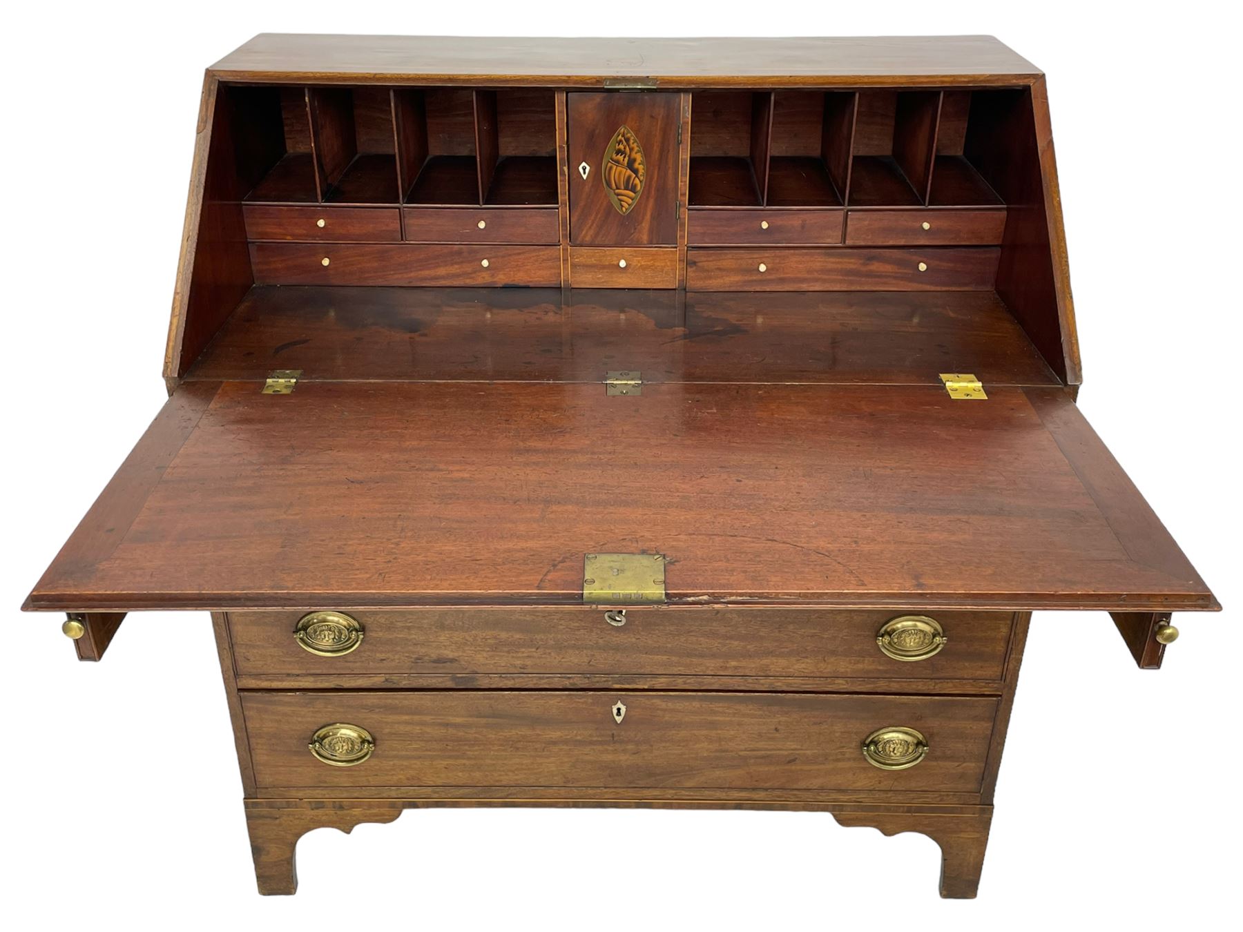 George III mahogany bureau, the fall-front banded and with boxwood stringing, enclosing fitted interior with pigeonholes and drawers surrounding a central cupboard with inlaid shell motif, the base with four graduating cock-beaded drawers, each with pressed brass handle plates with central lion masks and ivory escutcheons, on shaped bracket feet
This item has been registered for sale under Section 10 of the APHA Ivory Act