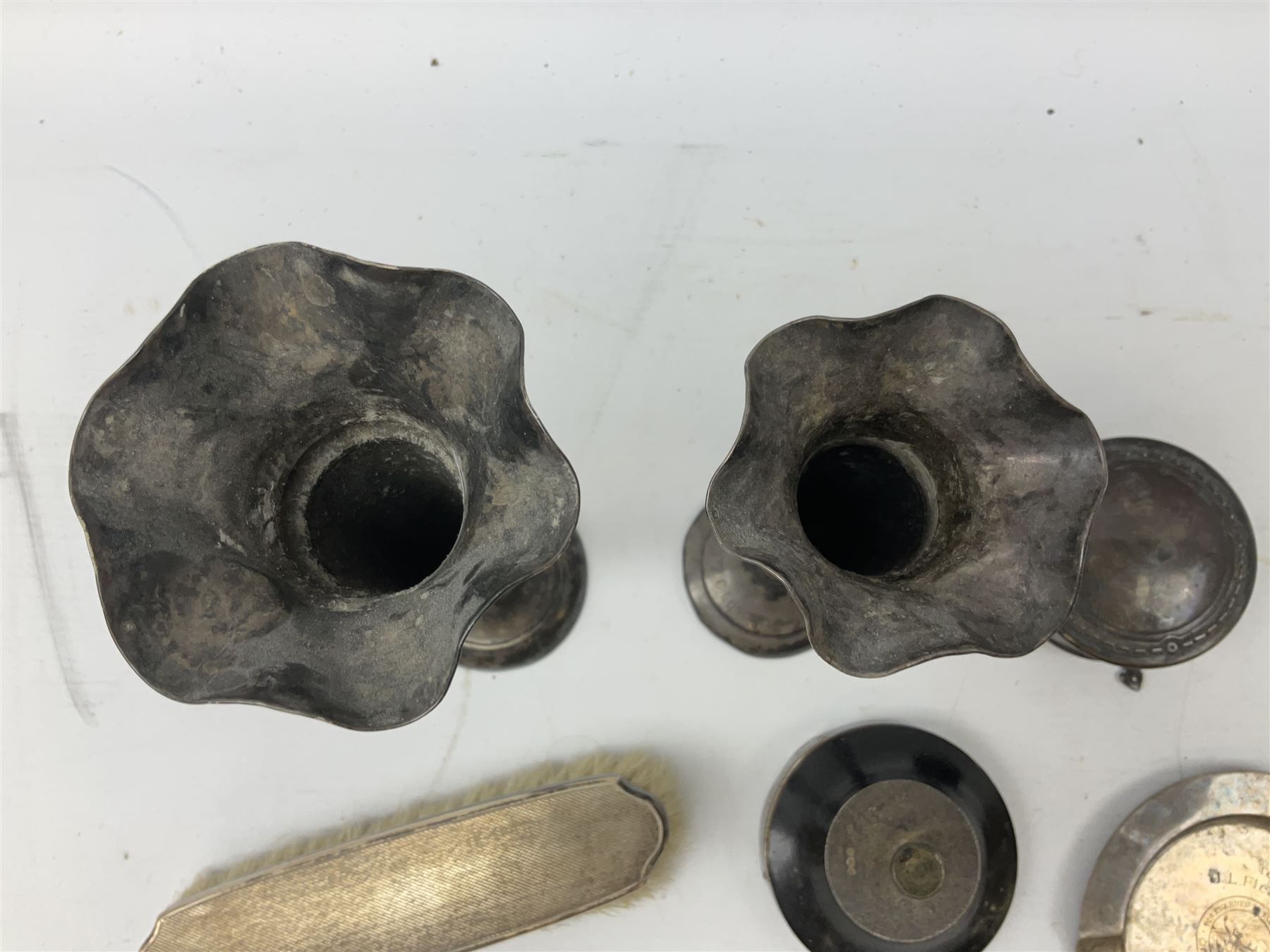 Two early 20th century silver trumpet vases to include a Martin Hall & Co Ltd example, silver circular box raised on three feet stamped Birmingham 1912, ashtray hallmarked London 1945, silver backed hair brush with engine turned decoration etc, tallest H19.5cm