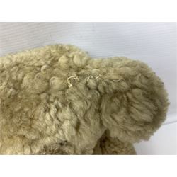 1950s sheepskin plush covered teddy bear with musical movement, the revolving head with applied eyes, leather nose and stitched mouth, jointed limbs with leather pads H50cm