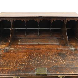 Georgian oak bureau, fall front with pierced brass escutcheon and handles, revealing a fitted interior, above two short over two long drawers, raised on bracket feet