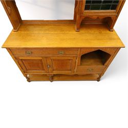 Maple & Co. - Arts & Crafts oak dresser with stained glass cupboard, raised section with pierced pediment above a mirrored back, with a stained glass fronted cupboard with fixed shelf, single long drawer, above a pair of fielded panels, with open recess above a short drawer, raised above a full length undertier with turned supports