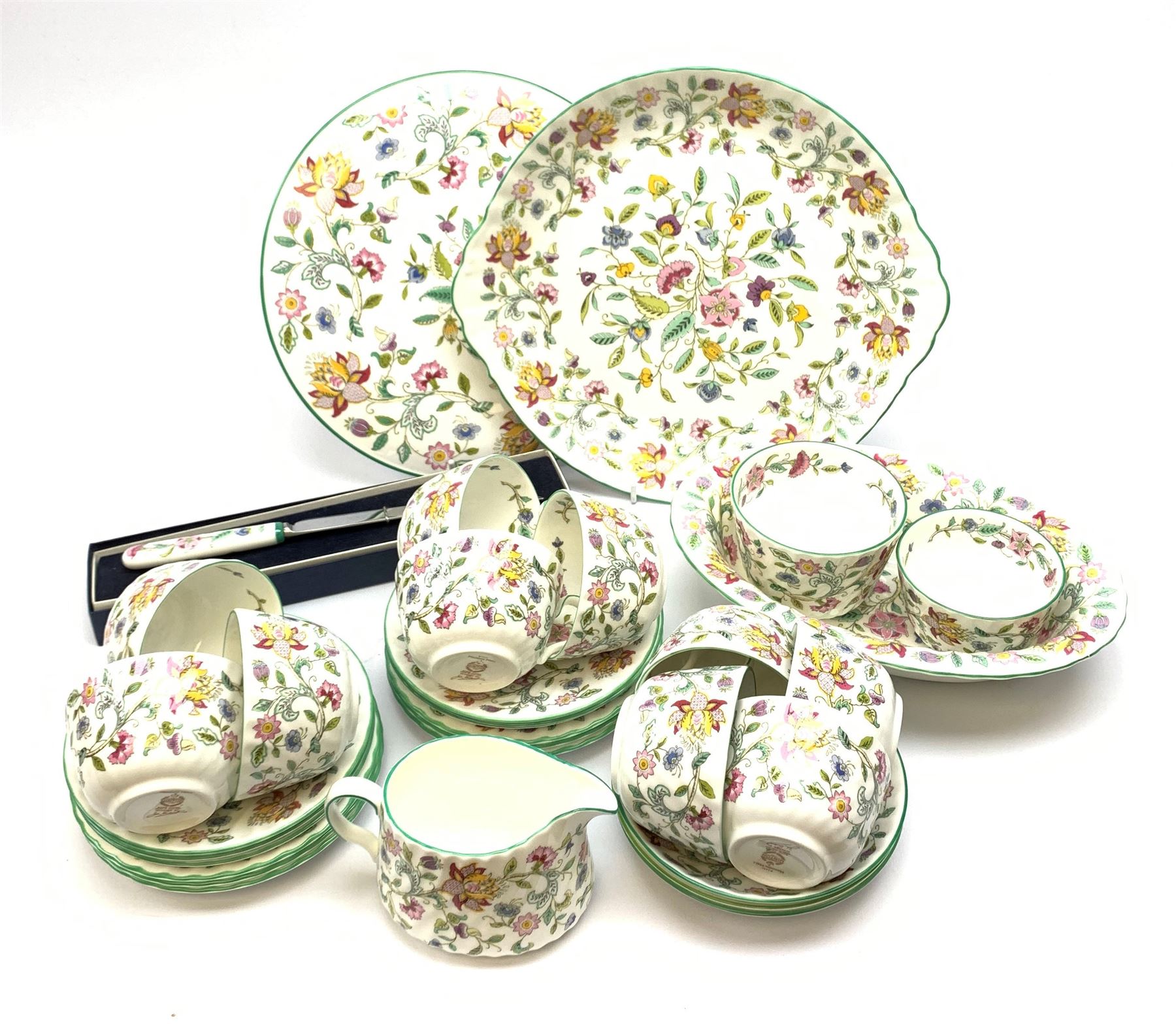 Minton Haddon Hall pattern tea wares, comprising stand, sandwich plate, oval serving dish, knife, eleven tea cups, six saucers, and three further smaller saucers, six side plates, open sucrier, and milk jug. 