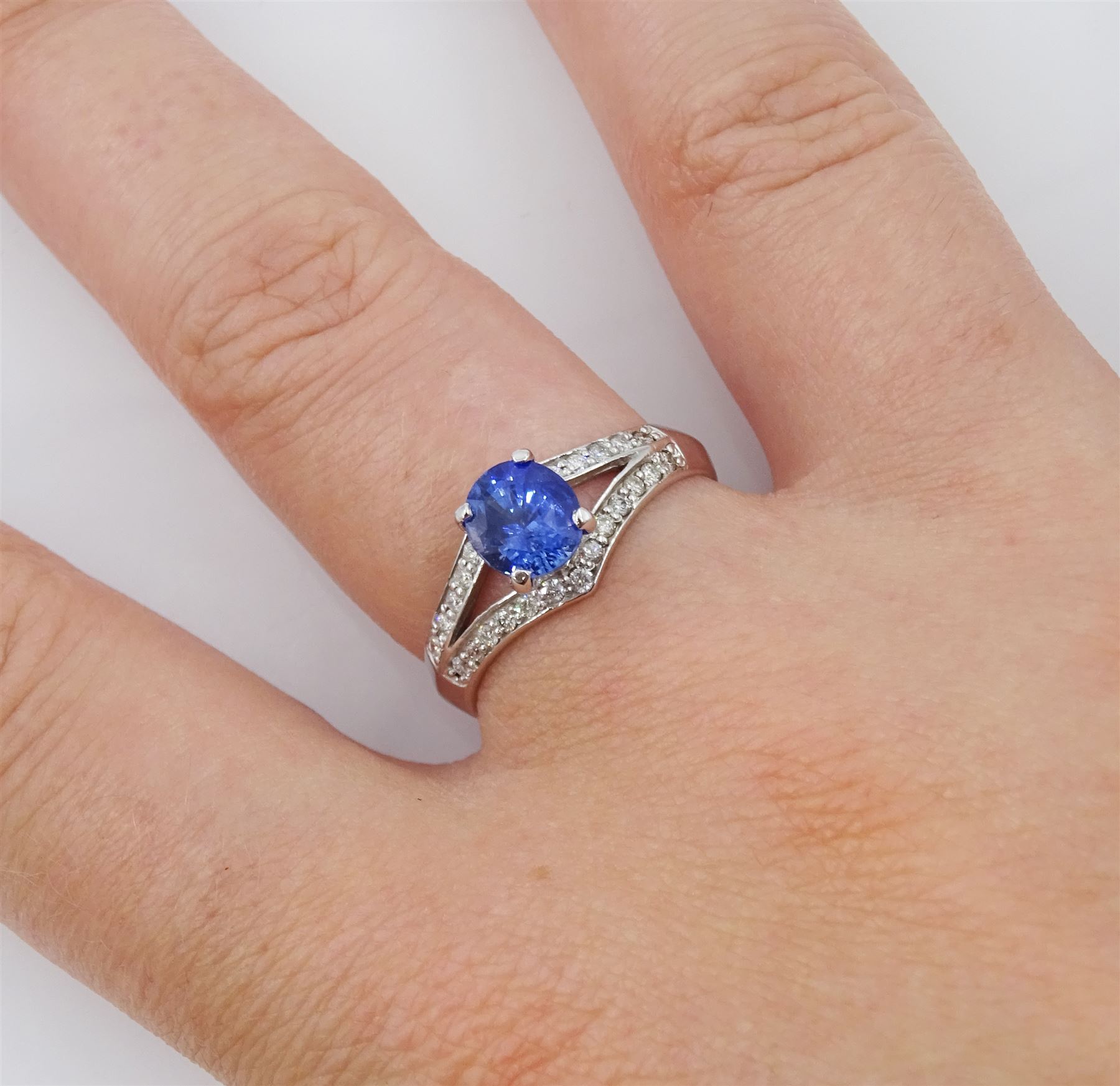 White gold sapphire and diamond ring, single oval cut sapphire of approx 1.00 carat, with split design diamond set shoulders, hallmarked 14ct