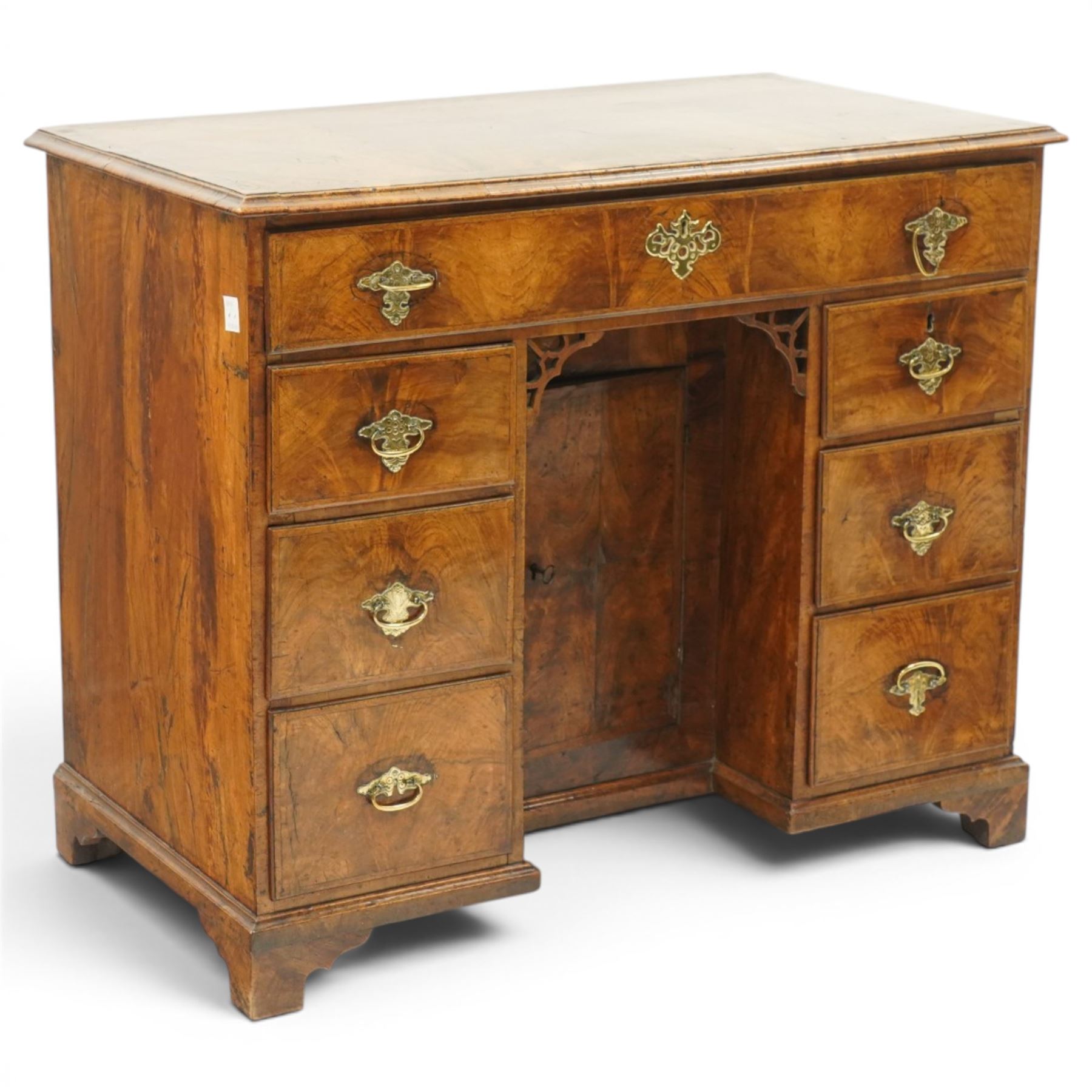 George III figured walnut kneehole desk, the rectangular top with feather and cross-banding with moulded edge, fitted with single frieze drawer over pierced spandrels and recessed cupboard, flanked by six graduating drawers, raised on bracket feet
Provenance: Kirkham Hall