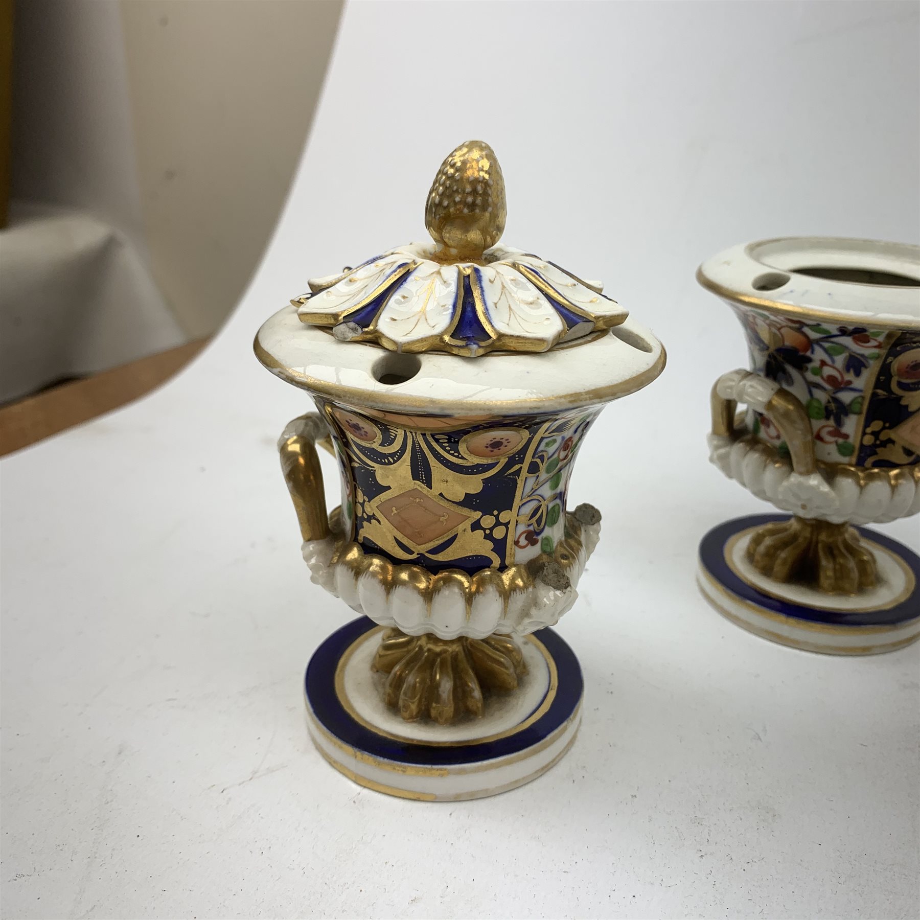 Three Bloor Derby Imari pattern twin handle urms, two examples with covers, each with mark beneath, H12cm, (all a/f), together with a pair of late 19th century Royal Crown Derby Imari pattern urns and covers, each with mark beneath, H13cm, (one significantly a/f). 