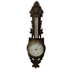 A 1920s oak cased patented aneroid barometer with openwork decorative carving, 8” enamel dial recording air pressure from 26 to 32 inches with weather predictions in gothic script, steel indicating hand and brass recording hand within a brass bezel and flat glass (glass cracked), with a boxed mercury thermometer recording the temperature in degrees centigrade and Fahrenheit.    

