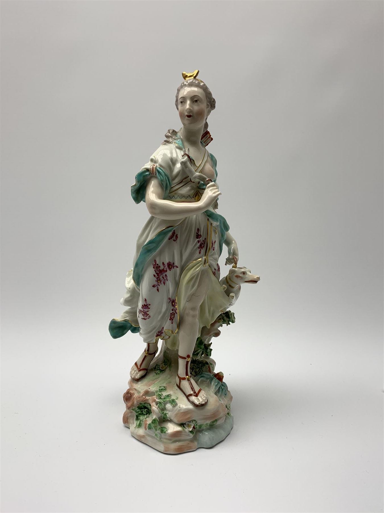 Mid 18th century Derby porcelain figure modelled as Dianna the Huntress, with quiver of arrows upon her back and dog by her side, upon a naturalistically modelled base, with patch marks beneath and collectors labels, H26cm