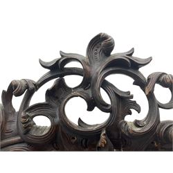 Early 20th century Italian walnut armoire wardrobe, the pierced and scrolling pediment carved with acanthus leaf detail, flanked by two scrolling cartouche with matching corbels below, the two panelled doors with applied carved rinceaux slips, with a central spiral turned upright, enclosing single shelf and hanging rail, raised on scroll feet