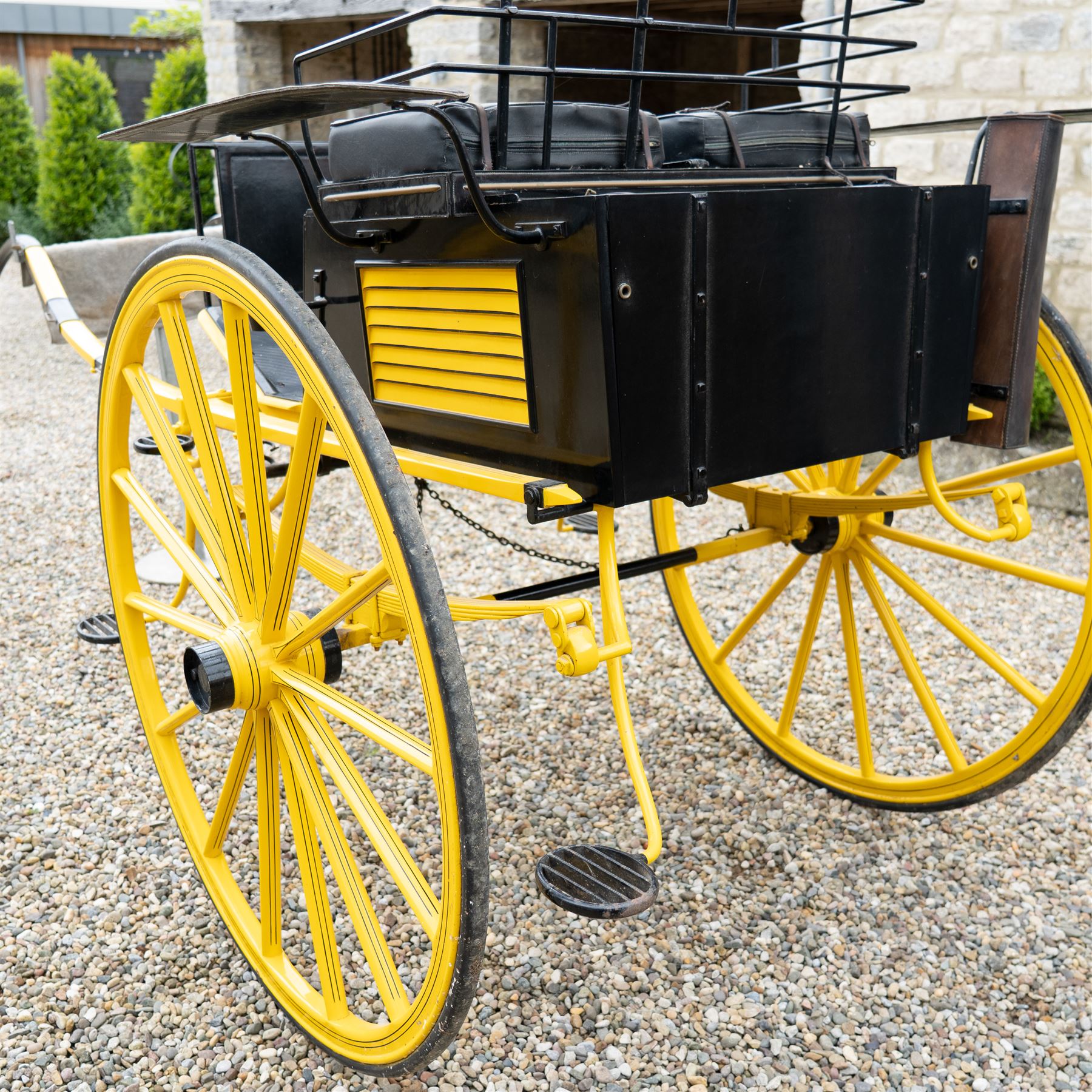 J. W. Thompson Dog Cart

A black and yellow painted two wheeled dog cart with elevated upholstered seat for two, buttoned black leather cushions, high back rail, folding front footboard, louvred sides, side steps, rear drop-down tailboard with chain stays, internal storage compartment, wooden spoked wheels, rubber tyres and shafts for a single horse. The wheel hubs are marked J W Thompson

Dimensions:
Overall length: 366 cm
Width: 160 cm
Height: 190 cm

Wheel Diameter:
Wheels: 139 cm

Seating:
Driver and passenger: 2
