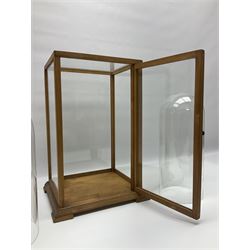 Tabletop glass display cabinet, with hinged door, together with two glass domes