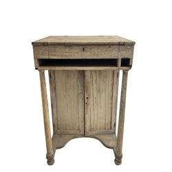 19th century clerk's desk, the hinged top supported by two turned uprights, fitted with cupboard enclosed by to panelled doors, on turned feet, the back painted with 'Reception' 