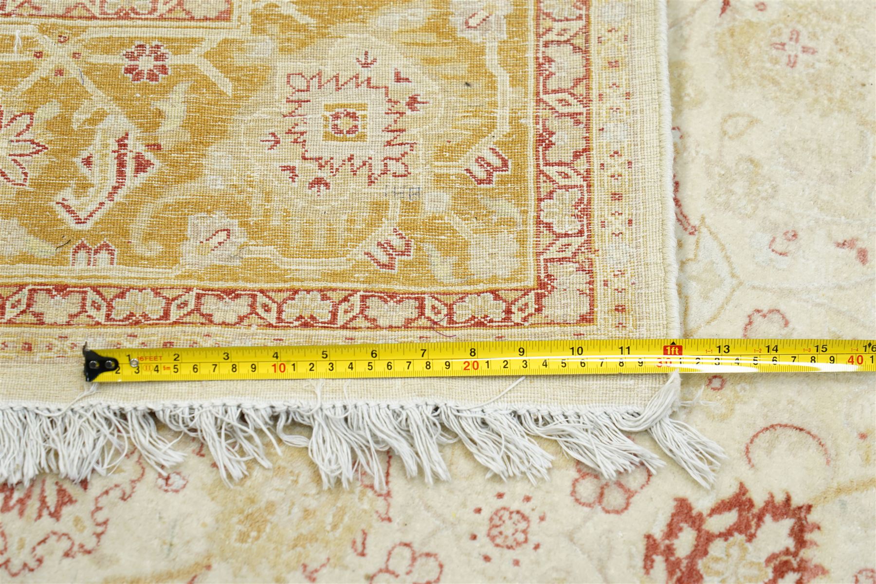 Modern Pakistani Oushak style wool hand-knotted carpet,  ivory field with an all-over scrolling floral vine design in soft tones of madder red and pale gold, enclosed by a conforming border, with cotton fringe ends  