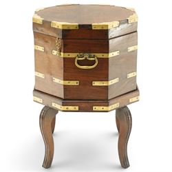 Late 18th century Anglo-Indian padouk and brass-bound octagonal cellarette or wine cooler, the hinged lid enclosing a vacant interior, the panelled body with applied brass strapwork, pierced escutcheon and side carrying handles, raised on a separate stand terminating to four fluted and reeded cabriole supports