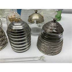 Collection of glass beehive honey pots, to include a blue slag example, milk glass, pink, green, etc together with four white metal examples (16) 