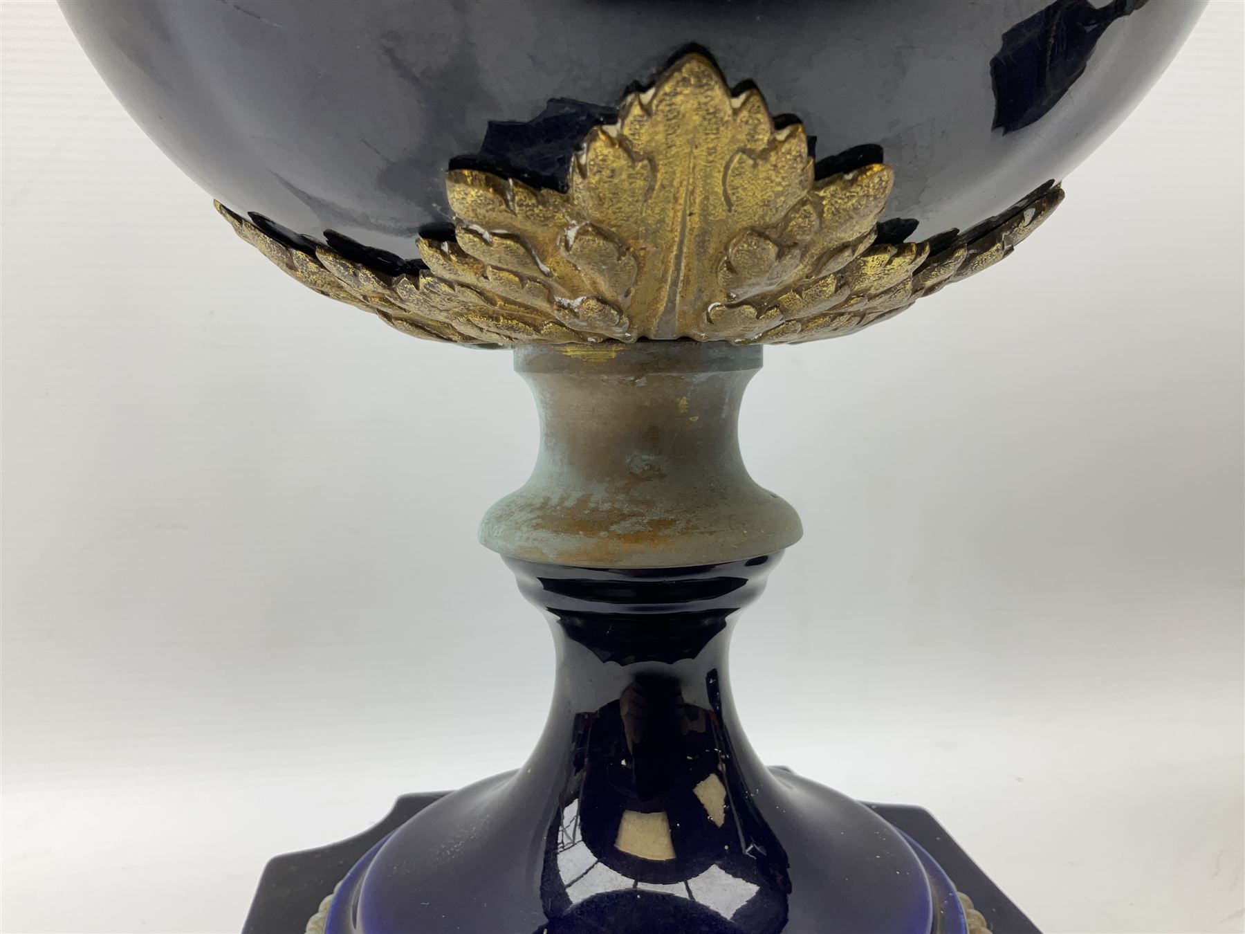 Pair of French large cobalt blue lidded urns, probably 19th century, the body decorated with ormolu ram's heads and ornate foliate design, the domed cover with brass berry finial, raised upon pedestal base with beaded decoration upon shaped plinth, H52cm