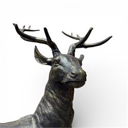 Pair of life-size cast iron garden or home stags, modelled standing upon oval plinths