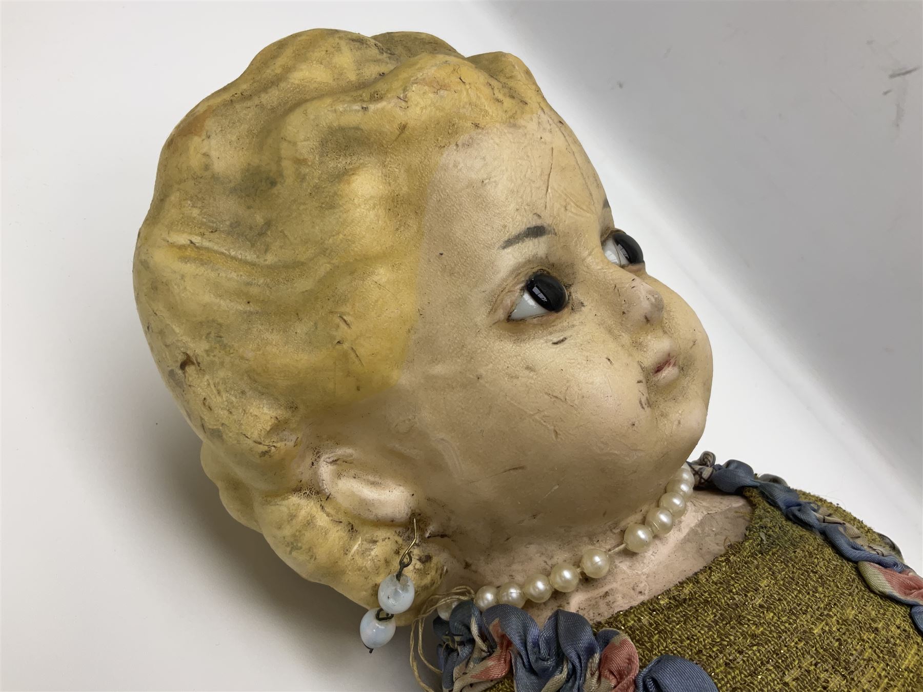 Victorian large wax over composition Pumpkin head doll, with inset dark glass eyes, moulded blonde hair in curls, stuffed body with carved and painted wooden limbs, grey painted boots, floral satin dress with netting underclothes H61cm