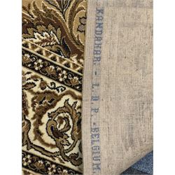 Persian design golden beige ground rug, the field with symmetrical scrolling foliate and floral designs, central floral medallion, bordered by a multi-layered band with floral and vine patterns in contrasting beige and dark brown tones