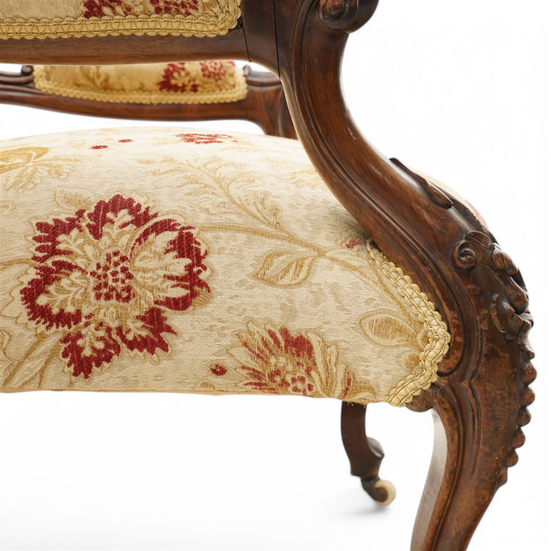 Victorian Ladies and Gentleman's carved walnut drawing room chairs, each with shaped cresting rail carved with scrolls and flowerheads, upholstered in pale gold floral fabric, raised on foliate-carved cabriole supports terminating to brass and ceramic castors