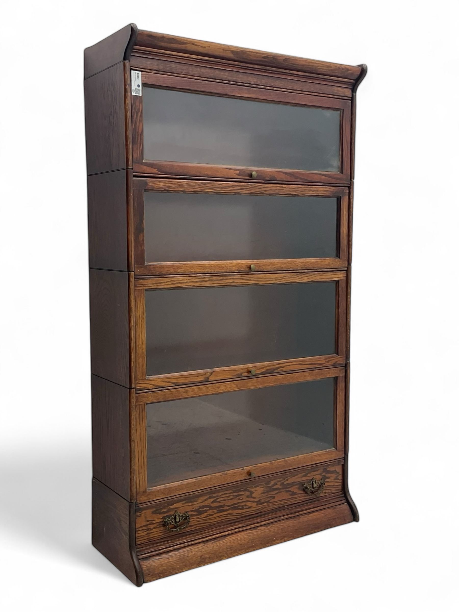 Early 20th century oak stacking library bookcase, four sections enclosed by hinged and sliding glazed doors, fitted with single drawer 