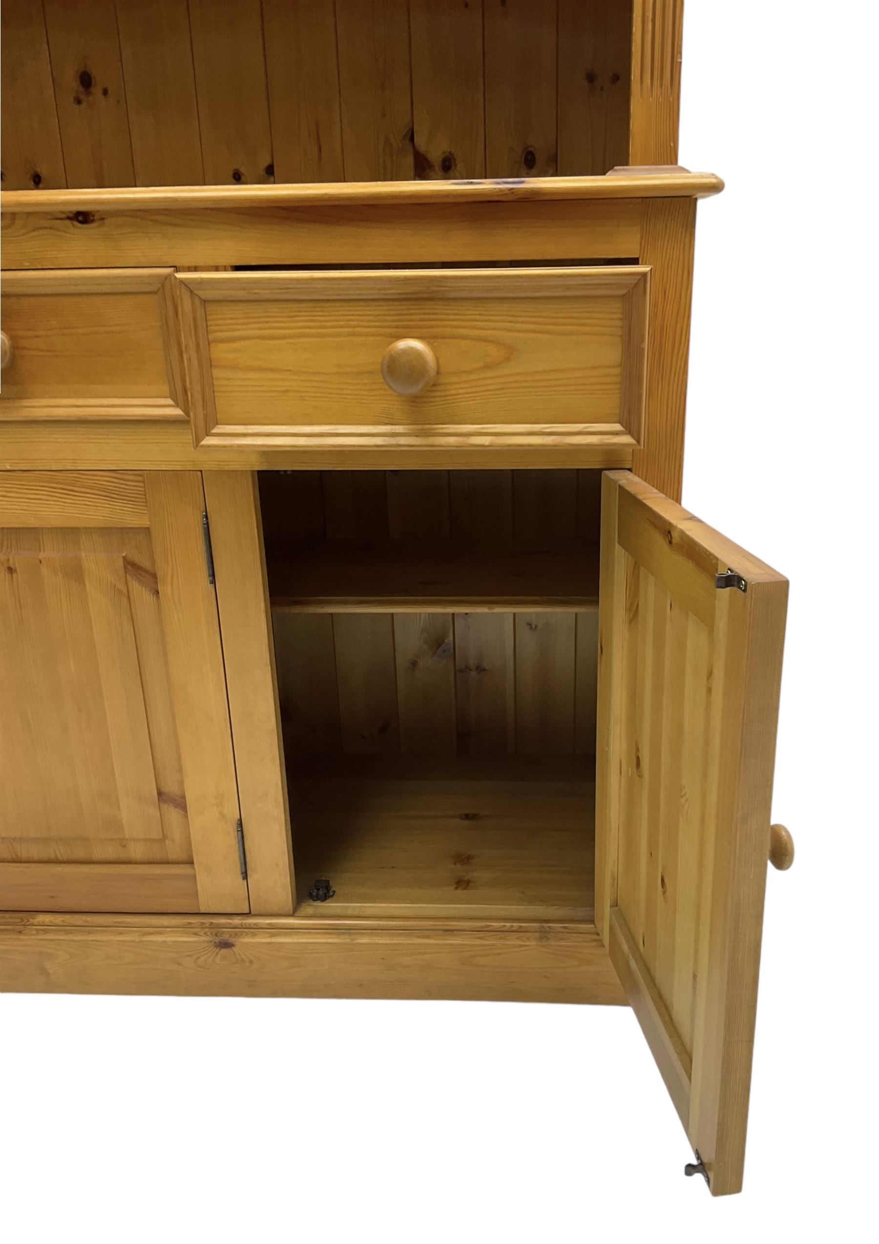 Traditional pine dresser, the rack fitted with two shelves flanked by glazed cupboards, the base with three drawers over three panelled cupboards