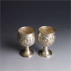 Pair of miniature Indian silver goblets, with embossed floral and foliate decoration, H6.5cm