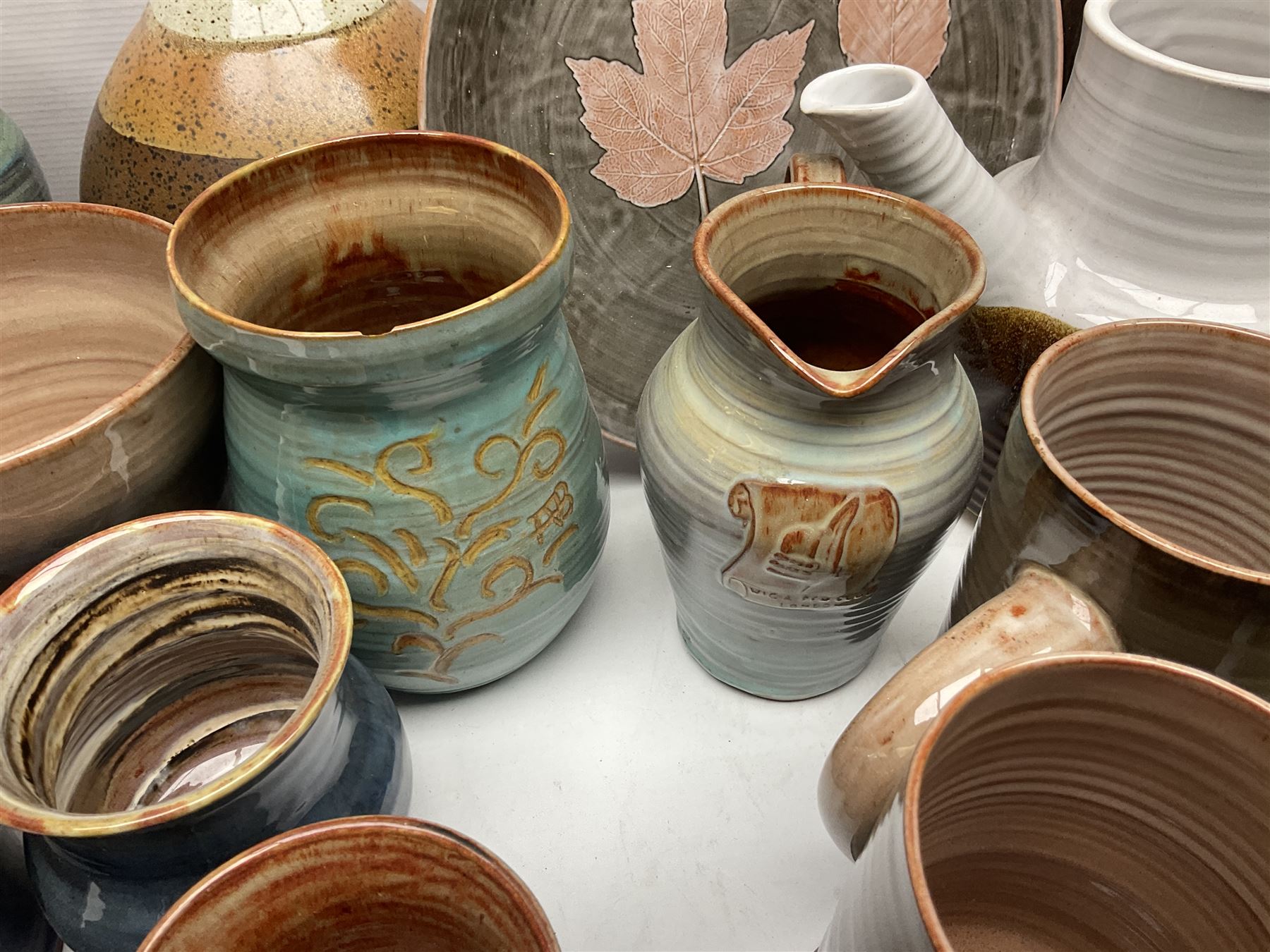Wold studio pottery tankards, in various colours and relief decoration together with other studio items including vases, jugs and pots 