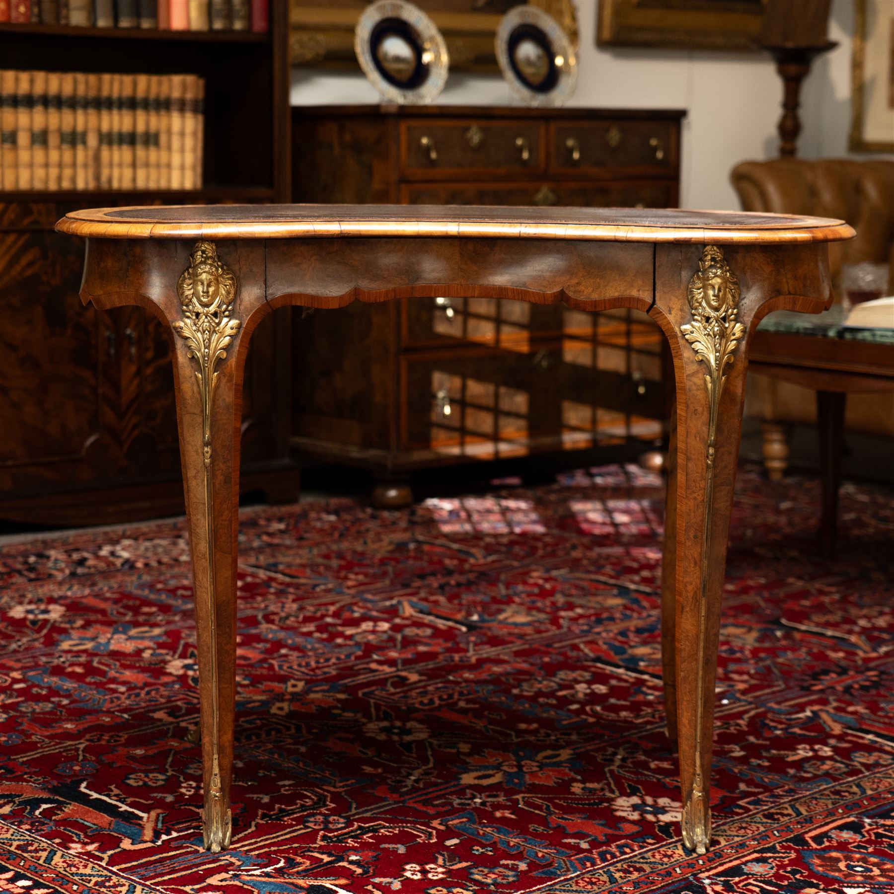 Gillow & Company (1862-1897) - Victorian figured walnut kidney shaped writing table, the shaped top inset with oxblood leather writing surface with embossed edge, surrounded by banded burr-walnut and crossbanding with moulded edge, fitted with single shaped frieze drawer flanked by scalloped side-aprons, raised on tapering and chamfered cabriole supports embellished with ormolu mounts in the forms of maidens over tapering acanthus leaves, the mounts trailing down the front of the legs to terminate to ormolu scroll feet, stamped 'Gillow & Co 3576' to drawer interior
