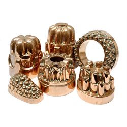 Six Victorian copper jelly moulds, five examples of castle type form, one example modelled as a bunch of grapes, largest H21cm